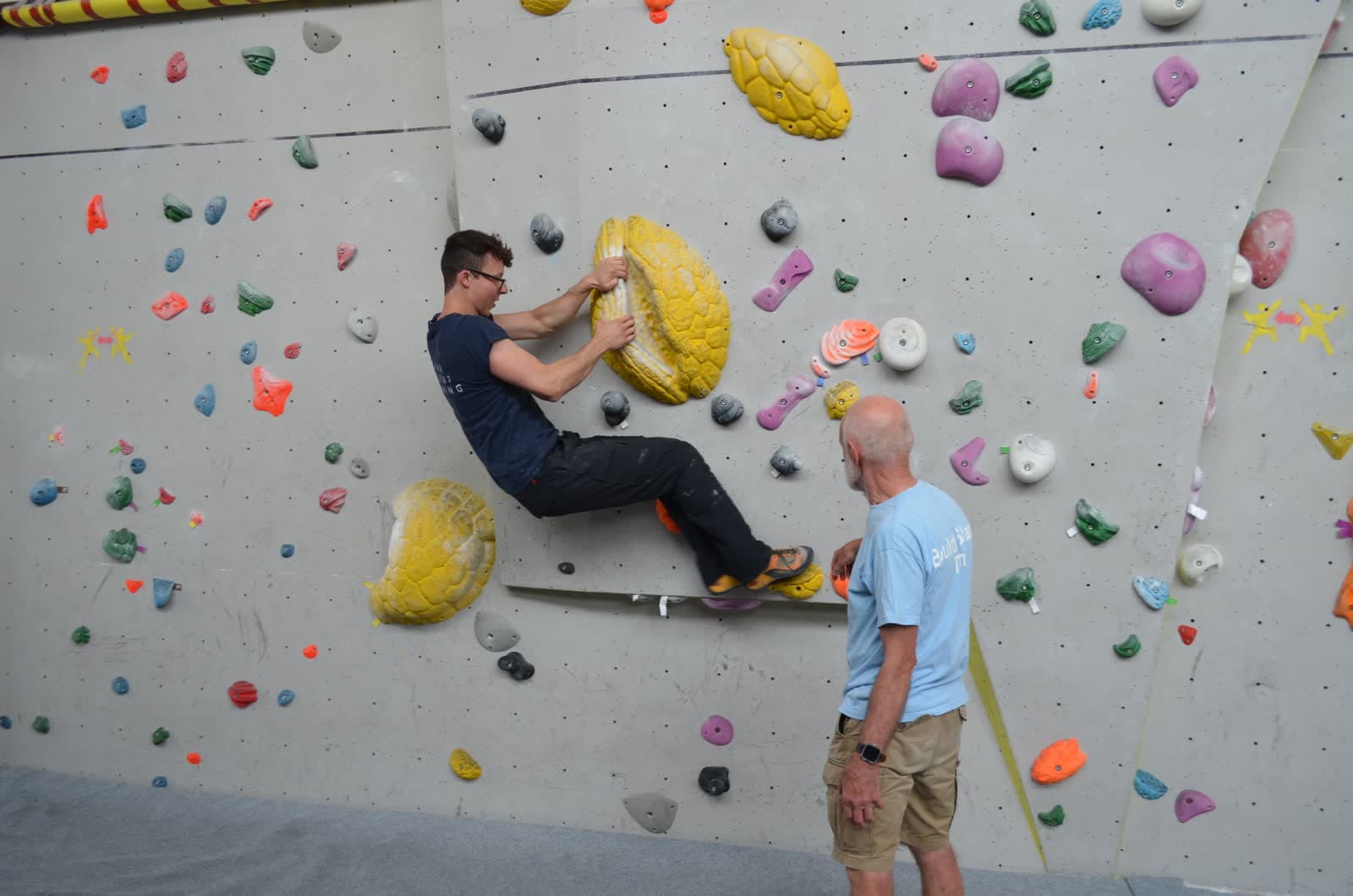 A climber pulling over the top of a problem