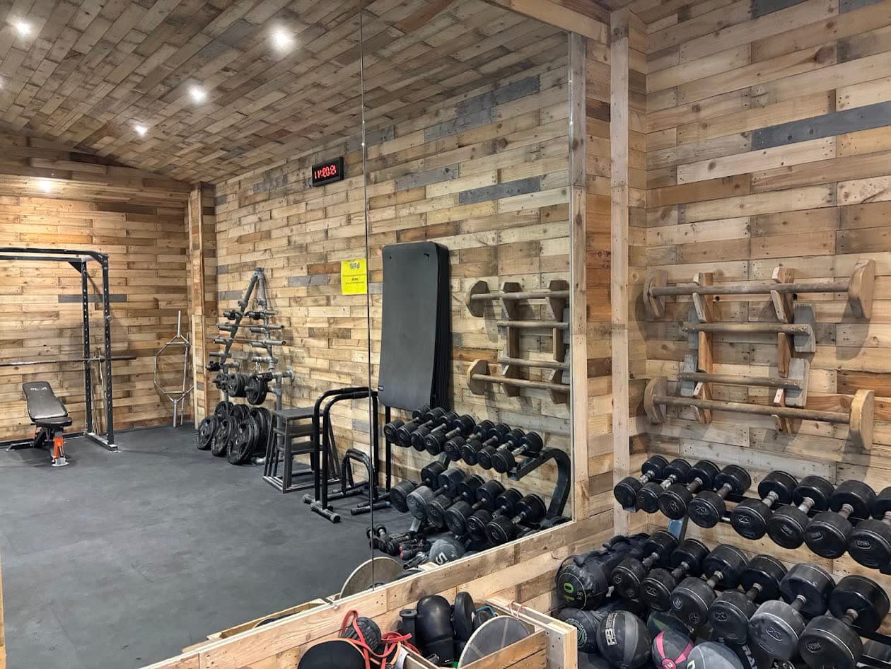 The training area, dumbbells and racks along the wall