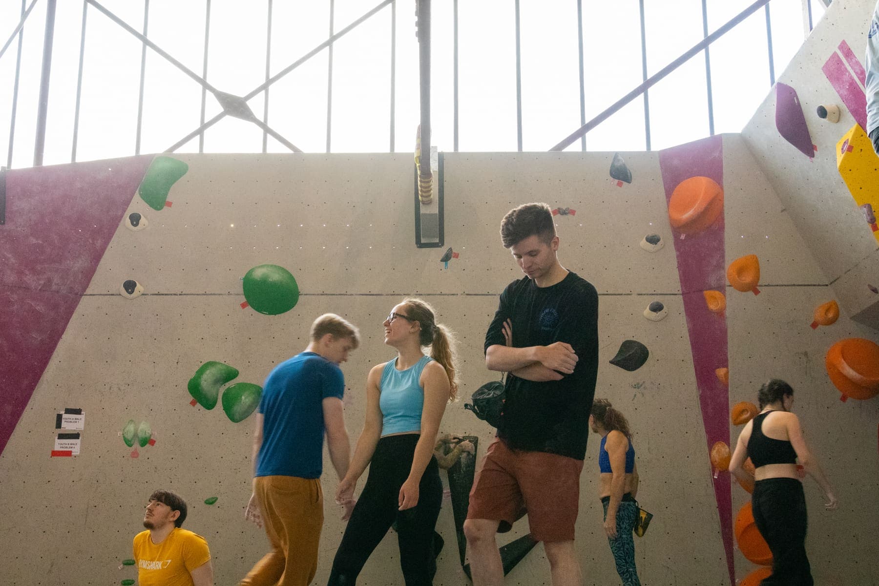 Competitors looking up at a problem between attempts